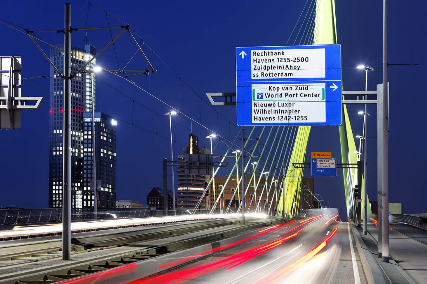 Fotografie van de ANWB bewegwijzering op de Erasmusbrug in Rotterdam bij nacht
