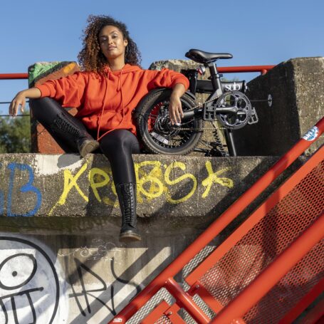 Locatie lifestyle fotografie van elektrische vouwfiets met model en graffiti