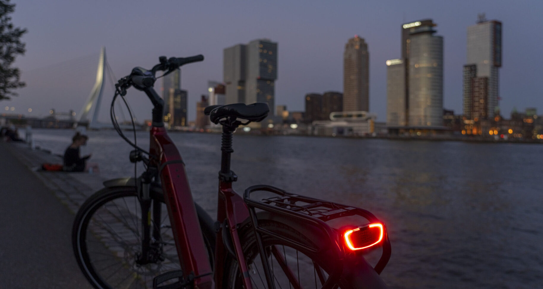 Lifestyle fotografie van fietsverlichting van Flyer voor e-bike met skyline van Rotterdam